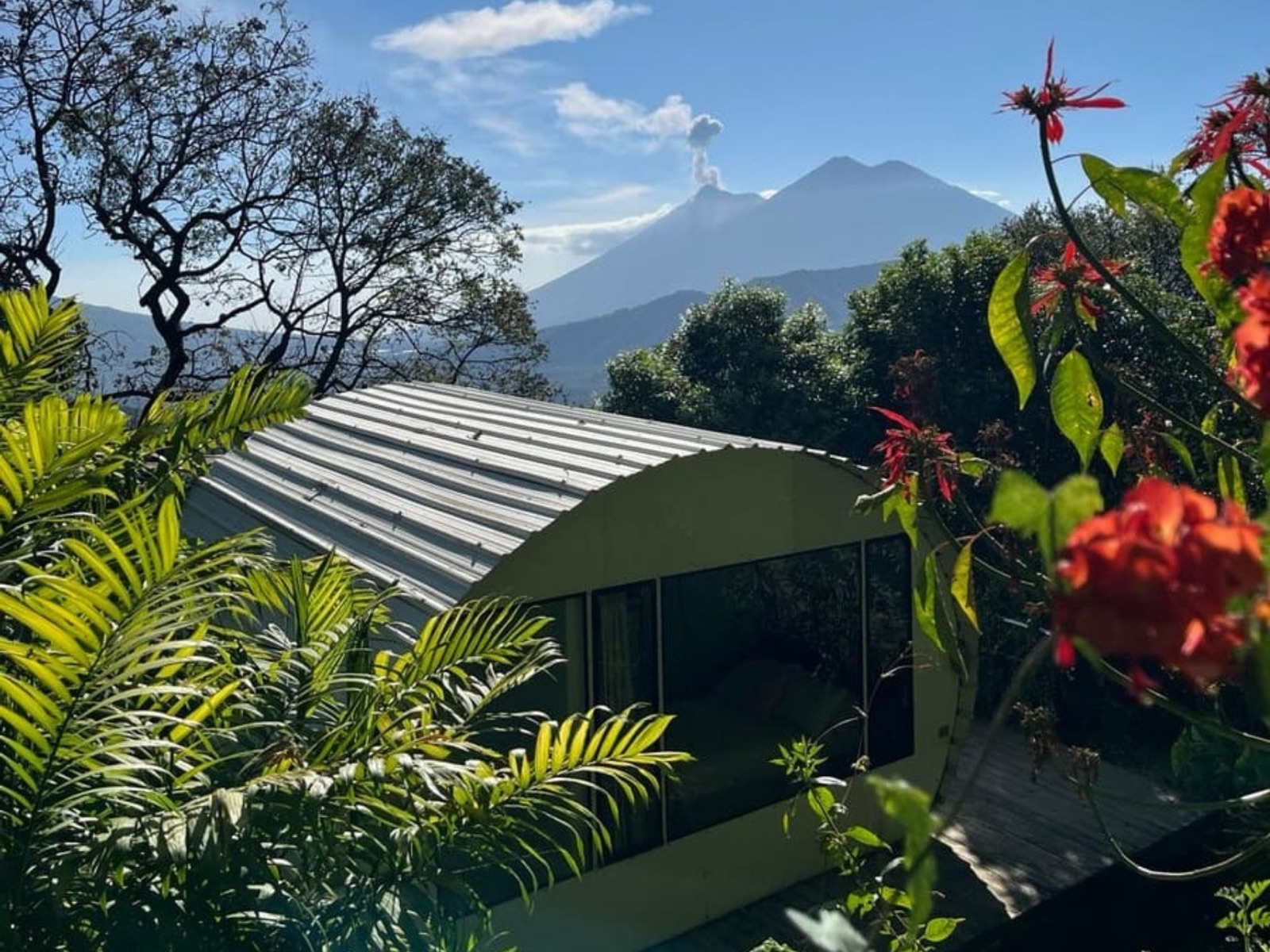 Tiny eco-house nestled among trees with volcano views, koi pond, and private elevated deck at Finca El Tambor, El Hato, Antigua Guatemala